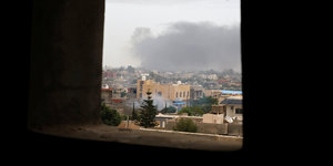 Rauchschwaden steigen über einer Stadt in Libyen auf.
