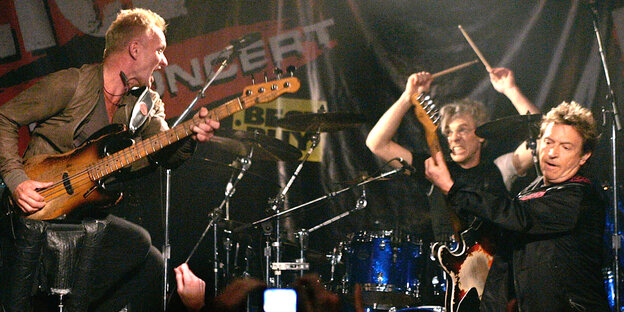 Die drei Bandmitglieder von Police auf der Bühne an ihren Instrumenten