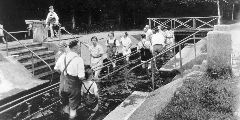 In Lederhose oder mit angehobenen Rock machen Kurgäste ihre Runden in einem Wasserbecken