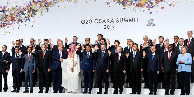Gipfelteilnehmer winken beim Gruppenbild zum Start des g20-Gipfels