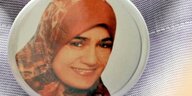 Zu sehen ist ein Button mit einem Porträtfoto von Marwa El-Sherbini, der an eine Jacke gepinnt ist