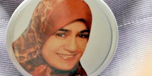 Zu sehen ist ein Button mit einem Porträtfoto von Marwa El-Sherbini, der an eine Jacke gepinnt ist