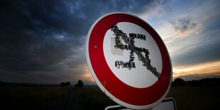 Straßenschild mit durchgestrichenem Hakenkreuz