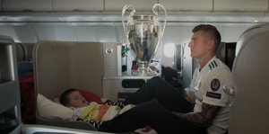 Toni Kroos mit Sohn und Pokal im Flugzeug