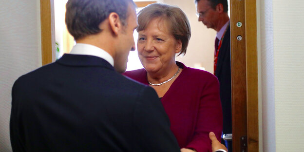 Angela Merkel (r), Bundeskanzlerin von Deutschland, begrüßt Emmanuel Macron, Präsident von Frankreich, am Rande eines Sondergipfels mit EU-Kollegen zur neuen Führung der Europäischen Union.