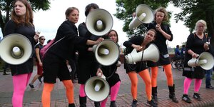 Frauen protestieren mit Megafonen