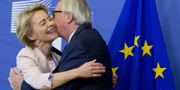 Juncker und von der Leyen umarmen sich vor Europaflagge
