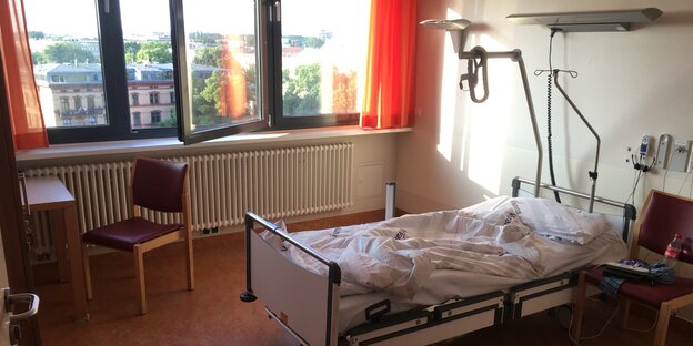 Ein Patientenzhimmer im Krankenhaus mit einem leeren aber benutzten Bett