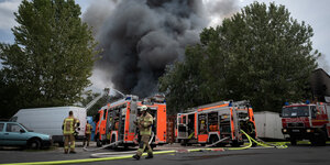 Brand im Dong-Xuan-Center in Lichtenberg: Dicke Rauchschwaden steigen hinter Feuerwehrautos auf