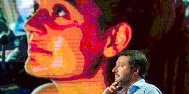 Im Hintergrund ein Vdeobild von Carola Rackete, im Vordergrund Italiens Innenminister Matteo Salvini
