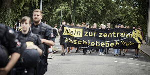 Demonstranten halten ein Plakat mit der Aufschrift "Nein zur zentralen Abschiebebehörde".