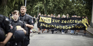 Demonstranten halten ein Plakat mit der Aufschrift "Nein zur zentralen Abschiebebehörde".