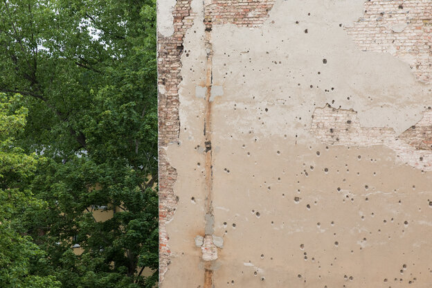 Brandmauer eines Hauses, daneben das Grün eines Baumes Brandmauer eines Hauses, daneben das Grün eines Baumes