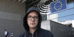 Ein Mann in Kapuzenpulli vorm EU-Parlament