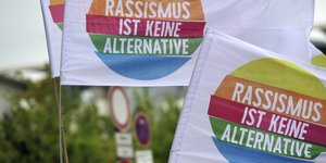 Zwei bunte Flaggen mit der Aufschrift "Rassismus ist keine Alternative"