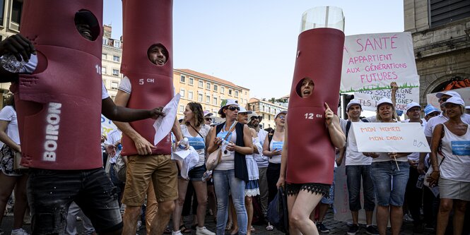 Inmitten einer Menschenmenge protestieren verkleidete Homöopathie-Anhänger