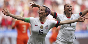 Megan Rapinoe läuft mit ausgebreiteten Armen übers Feld und freut sich