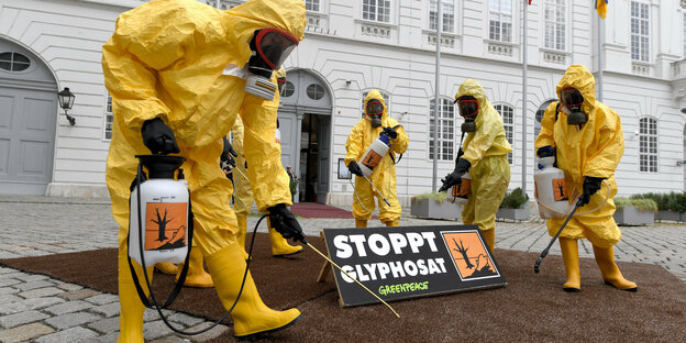 Mitglieder der Umweltorganisation Greenpeace tragen gelbe Schutzkostüme und Schutzmasken im Rahmen einer Protestaktion zum Thema Glyphosat-Verbot vor Beginn einer Sitzung des Nationalrates in Wien