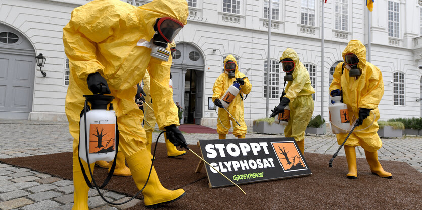 Mitglieder der Umweltorganisation Greenpeace tragen gelbe Schutzkostüme und Schutzmasken im Rahmen einer Protestaktion zum Thema Glyphosat-Verbot vor Beginn einer Sitzung des Nationalrates in Wien