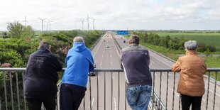 Schaulustige stehen auf einer Autobahnbrücke in Sachsen-Anhalt