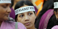 Eine Ffrau trägt ein Stirnband mit der Aufschrift "Gegen Gewalt an Frauen"