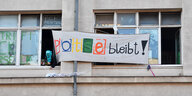 Jugendzentrum Potse in Schöneberg: Ein maskierter Jugendlicher befestigt am Fenster ein Transparent auf dem "Potse bleibt" steht.