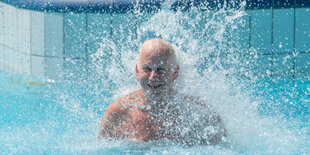 Ein Mann im Becken eines Freibades