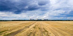 Ein abgeerntetes Kornfeld unter gewittrigem Himmel