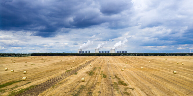 Ein abgeerntetes Kornfeld unter gewittrigem Himmel