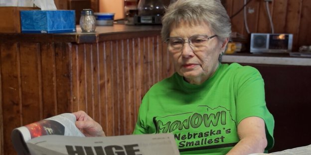 Die Protagonistin von „Monowi, Nebraska“ sitzt in ihrer Taverne und liest Zeitung.