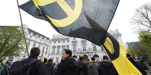 Identitäre mit Fahne auf einer Demonstration