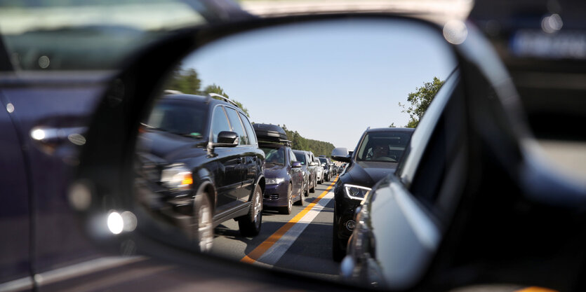 Im Rückspiegel eines Autos sind andere dahinterstehende Autos zu sehen