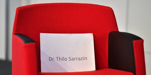 Ein roter leerer Sessel mit einem Schild, auf dem "Dr. Thilo Sarrazin" steht