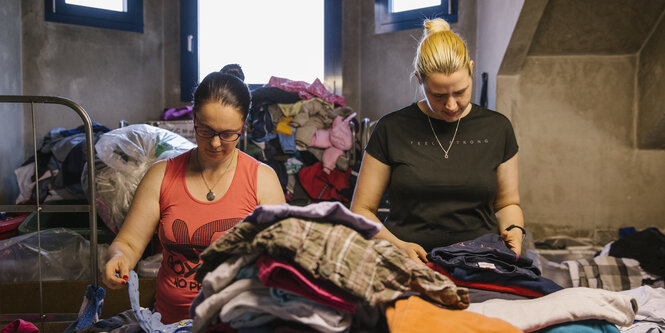 Zwei Frauen sortieren Kleidung