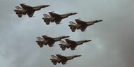 Durch grauen, wolkenverhangenen Himmel fliegen sechs britische Kampfjets.