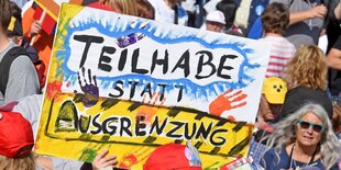 Schild auf einer Demonstration: "Teilhabe statt Ausgrenzung"