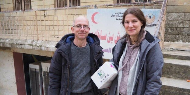 Stehen vor einem Schild des roten Halbmondes: Martin und Ioana Klopf