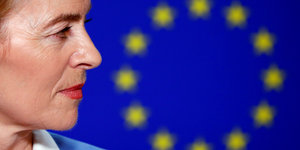 Ursula von der Leyens Gesicht im Profil vor einer EU-Fahne