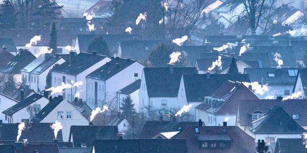 Schornsteine rauchen auf den Dächern einiger Häuser