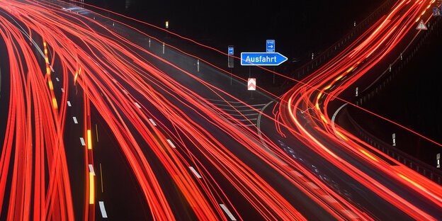 Rote Lichtstriemen auf einer Langzeitbelichtung einer Autobahnauffahrt