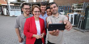 Die Integrationsbeauftragte Staatsministerin der Bundesregierung, Annette Widmann-Mauz, macht ein Gruppenselfie mit Menschen aus Syrien und Marokko