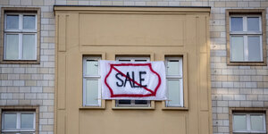 Protestplakat an einem Haus in der Karl-marx-Allee: "Sale" durchgestrichen