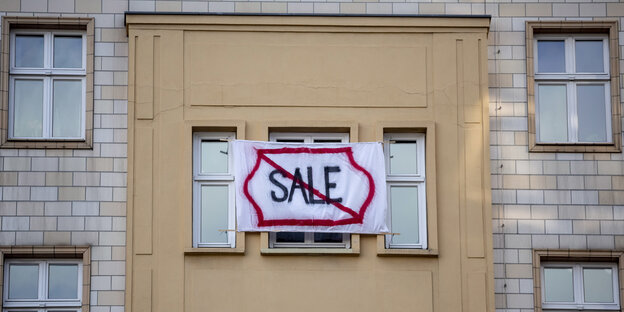 Protestplakat an einem Haus in der Karl-marx-Allee: "Sale" durchgestrichen