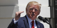 Donald Trump mit rotem Kopf steht gestikulierend an einem Mikrofon
