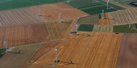 Blick von oben auf abgemähte Felder mit Windrädern