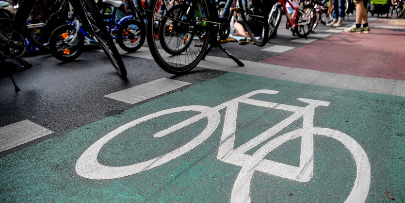 Auf grünem Untergrund ist ein weißes Fahrrad aufgemalt