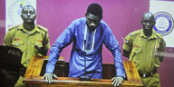 Der Ugandische Popstar Bobi Wine vor Gericht mit zwei Wächtern