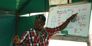 Nigerianischer Lehrer vor Tafel mit Chinesisch