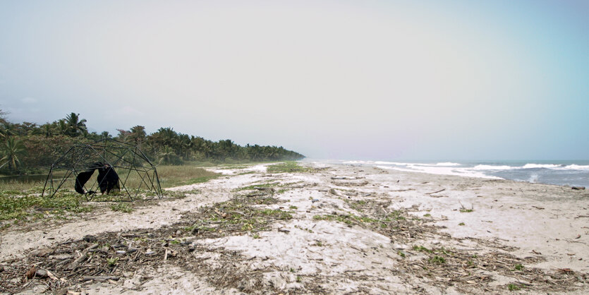 Ein fast leerer Strand, ein kleines Zelt wird aufgebaut