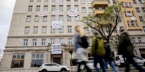 Protesttransparente gegen den Verkauf von Wohnungen an die Firma Deutsche Wohnen hängen aus Fenstern in der Karl-Marx-Allee